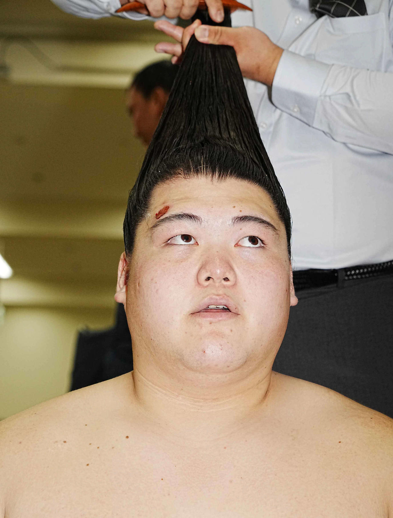 支度部屋で髪を整える王鵬