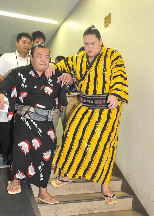 15年秋場所13日目、右足を痛め付け人に支えられ相撲診療所に向かう照ノ富士