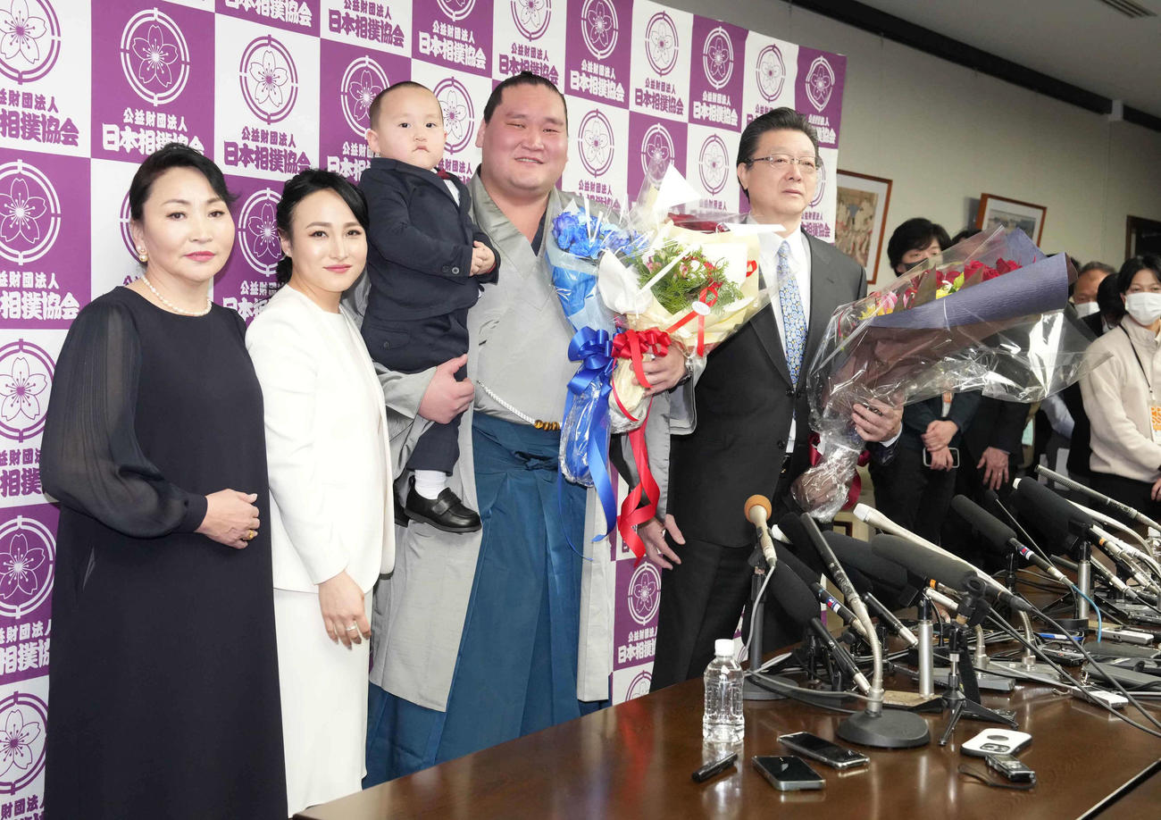引退会見を終えた元横綱照ノ富士は長男照務甚（てむじん）君を抱いて家族と記念撮影する。左から母オヨンエルデネさん、ドルジハンド夫人、右は師匠の伊勢ケ浜親方（撮影・小沢裕）