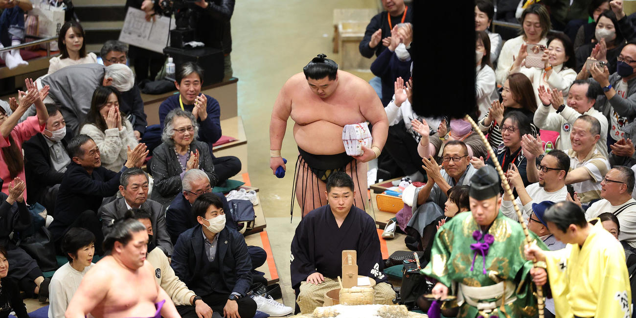 懸賞金の束を手に一礼し花道を引きあげる正代（撮影・中島郁夫）
