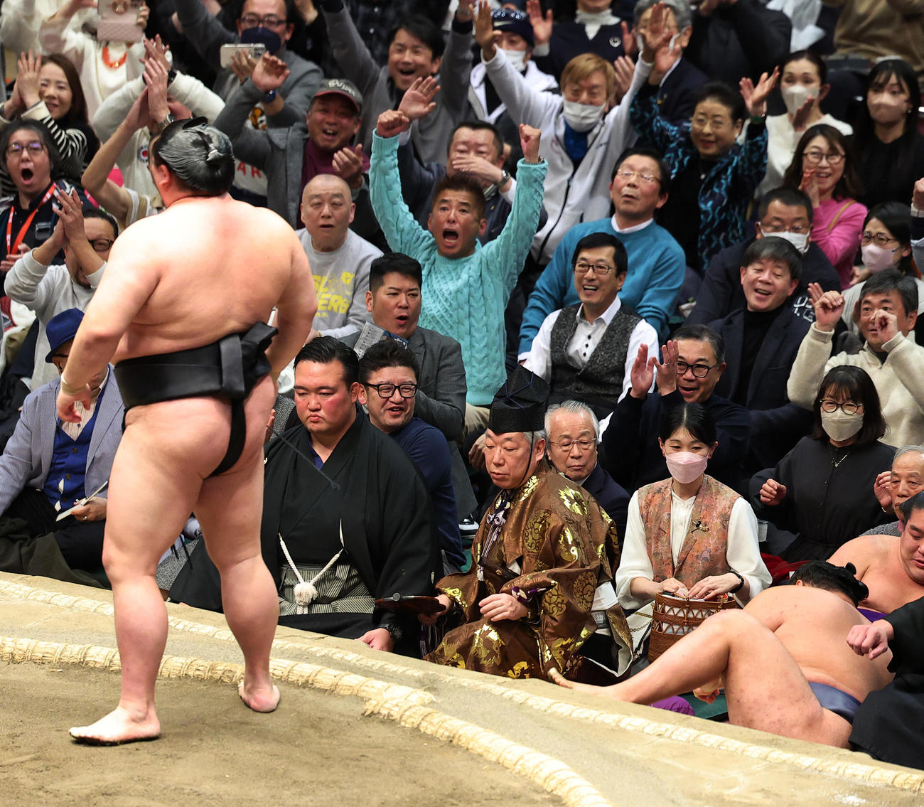 豊昇龍（右）を押し倒しで破る正代。客席では観戦する勝俣州和が渾身（こんしん）のガッツポーズ（撮影・中島郁夫）