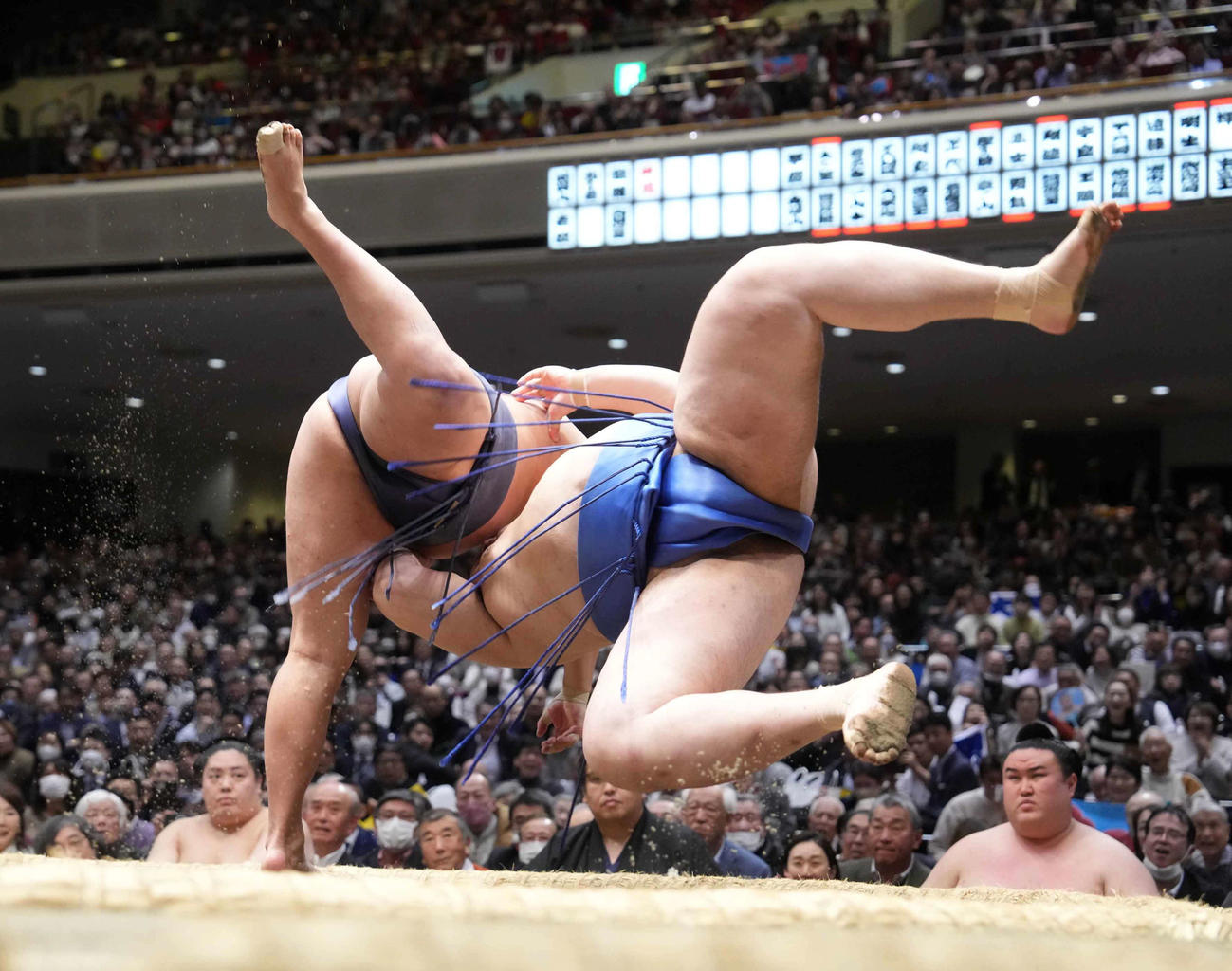 豊昇龍（左）は大の里を首投げで破る。右は土俵下控えの金峰山（撮影・小沢裕）