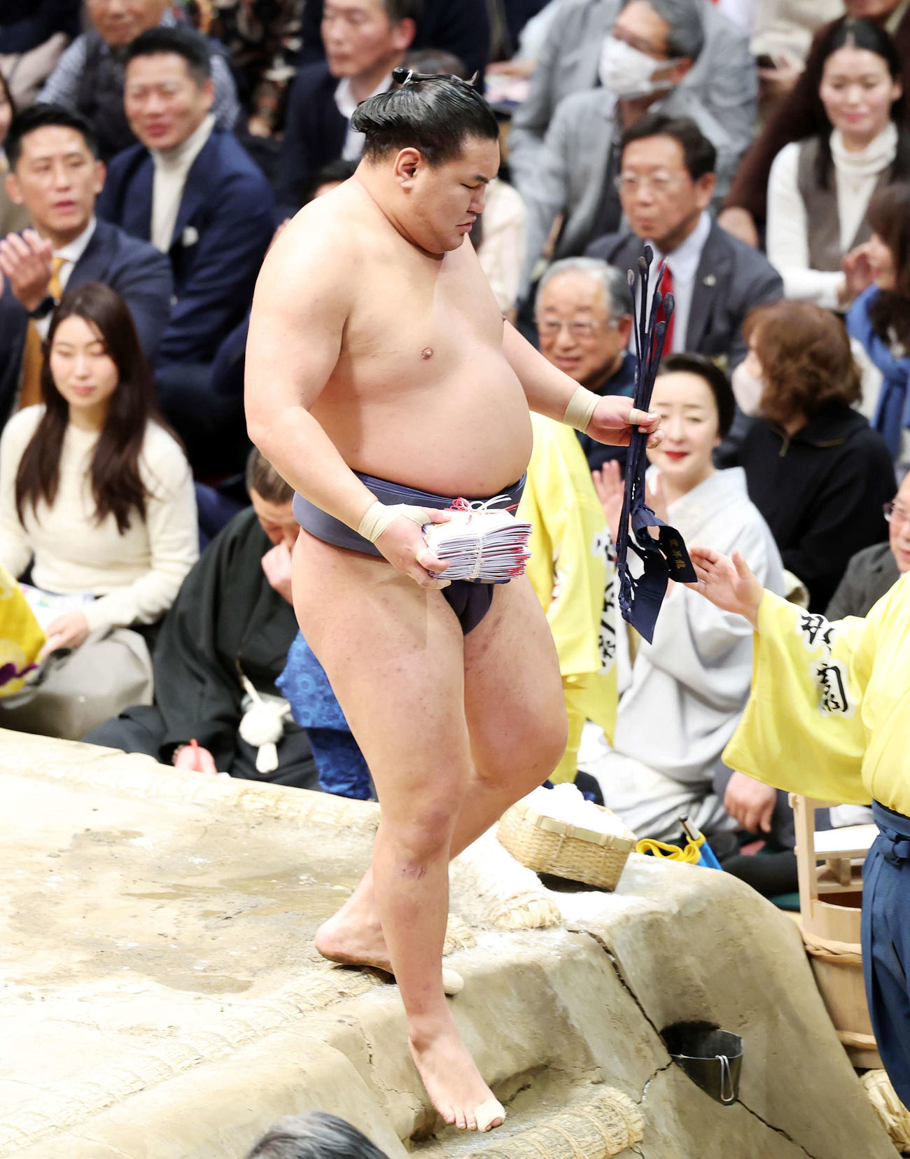 懸賞金の束を手に土俵を引き揚げる豊昇龍（撮影・鈴木正人）