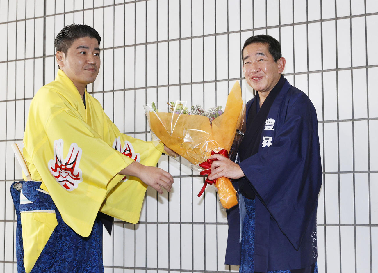 花束を受け取る立呼び出しの次郎（右）＝両国国技館（共同）