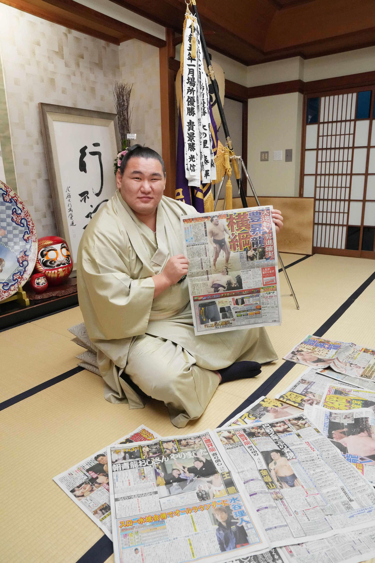 一夜明け会見で優勝を報じた本紙を手に笑顔を見せる豊昇龍（撮影・小沢裕）