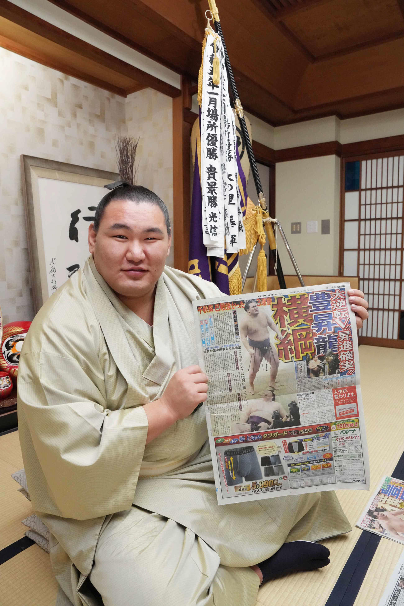 一夜明け会見で優勝を報じた本紙を手に笑顔を見せる豊昇龍（撮影・小沢裕）