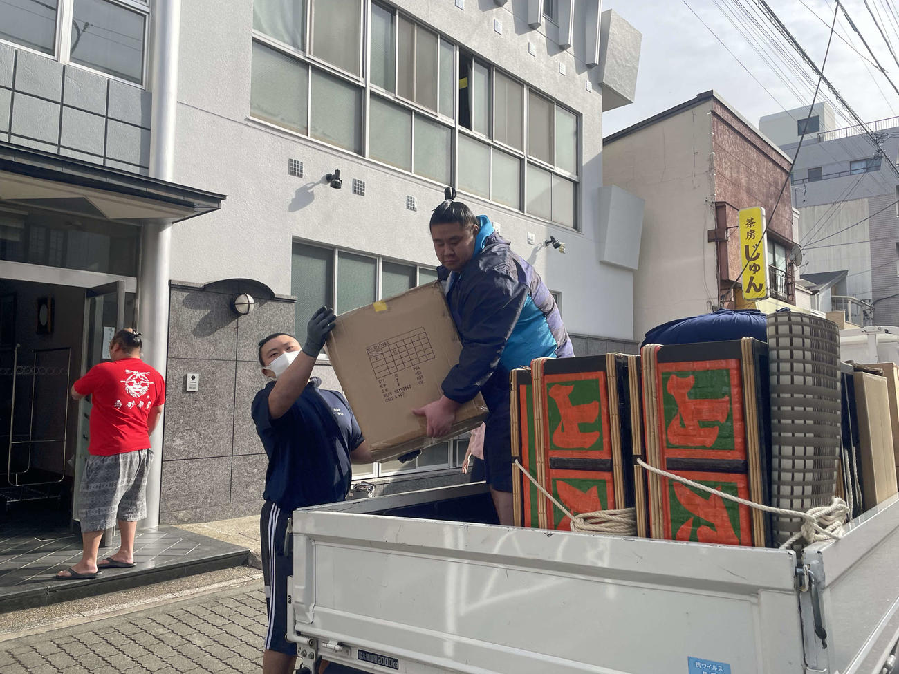 引っ越しの荷物をトラックに積む高砂部屋の力士たち（撮影・奥岡幹浩）