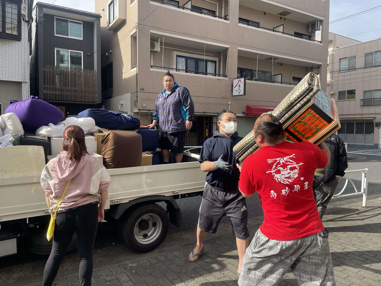 引っ越しでトラックに荷物を運ぶ高砂部屋の力士たち（撮影・奥岡幹浩）