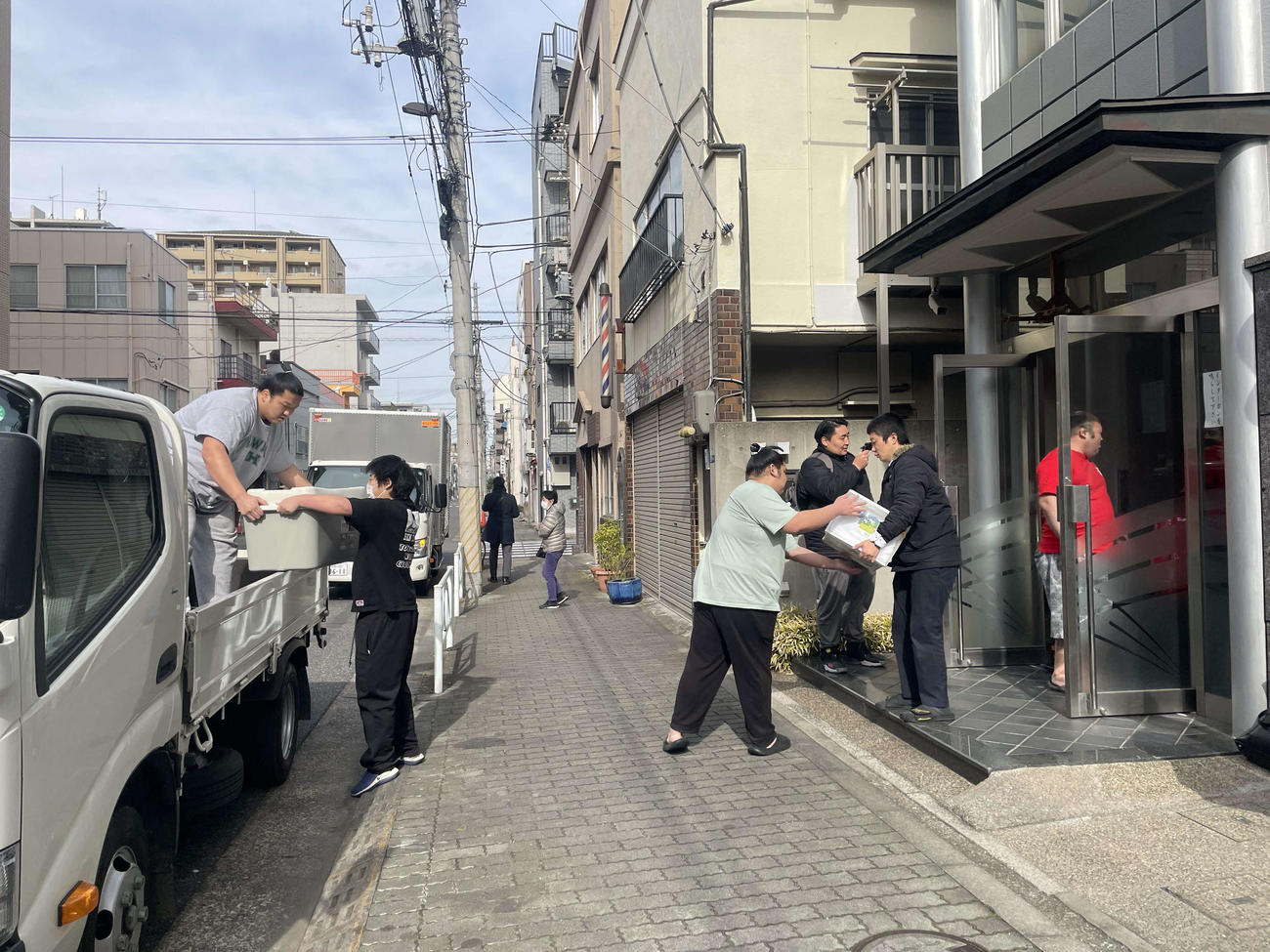 引っ越しの荷物をトラックに運ぶ高砂部屋の力士たち（撮影・奥岡幹浩）