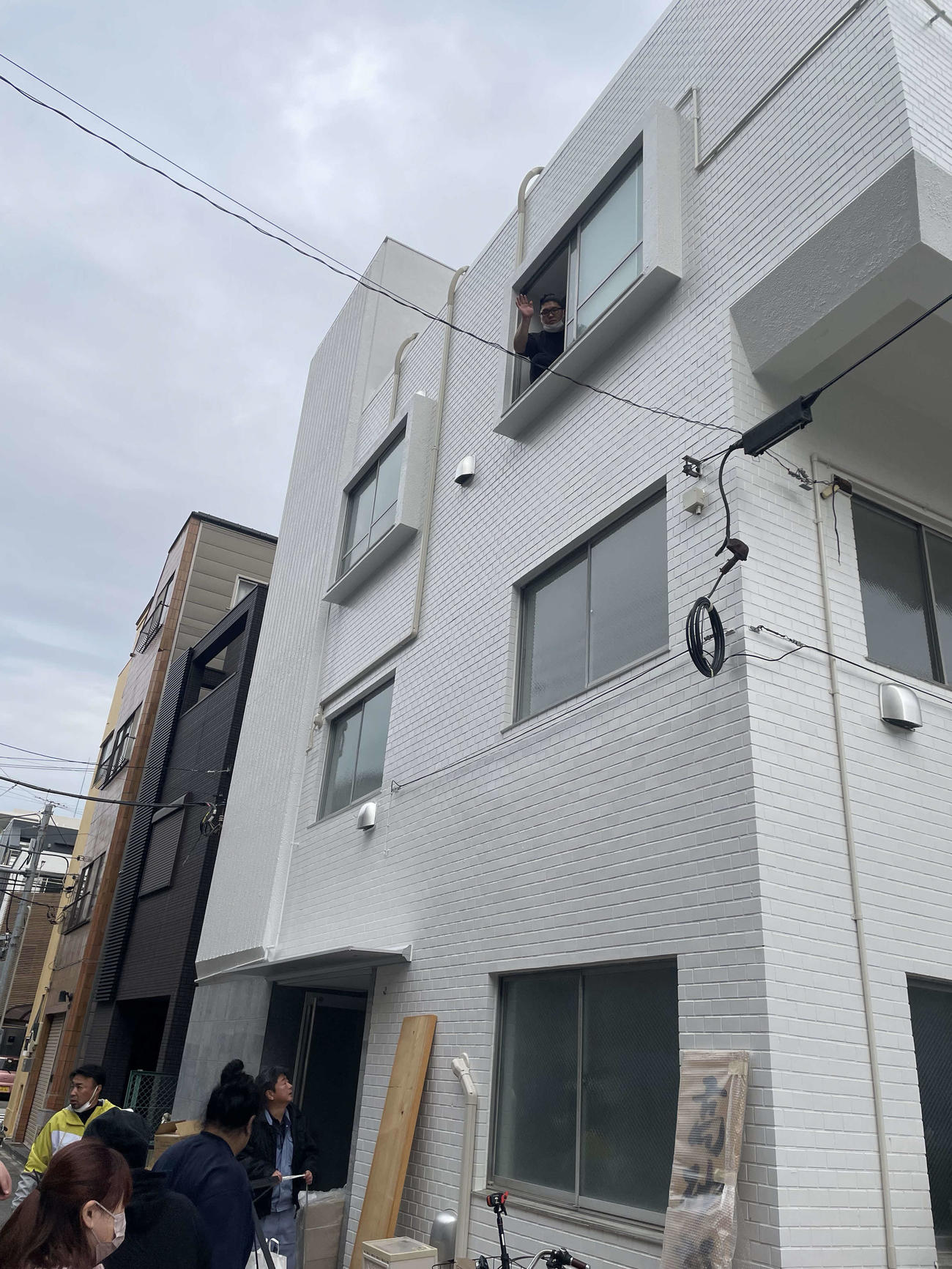 移転先の部屋から手を振る高砂部屋の力士（撮影・奥岡幹浩）