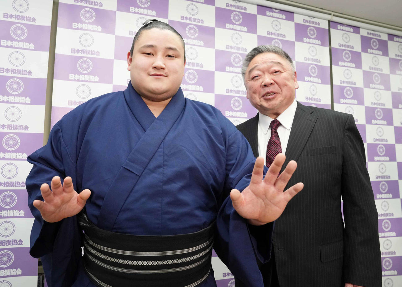春場所の新十両昇進会見に臨み得意の突き押しでポーズを決める若ノ勝。右は常盤山親方（撮影・小沢裕）