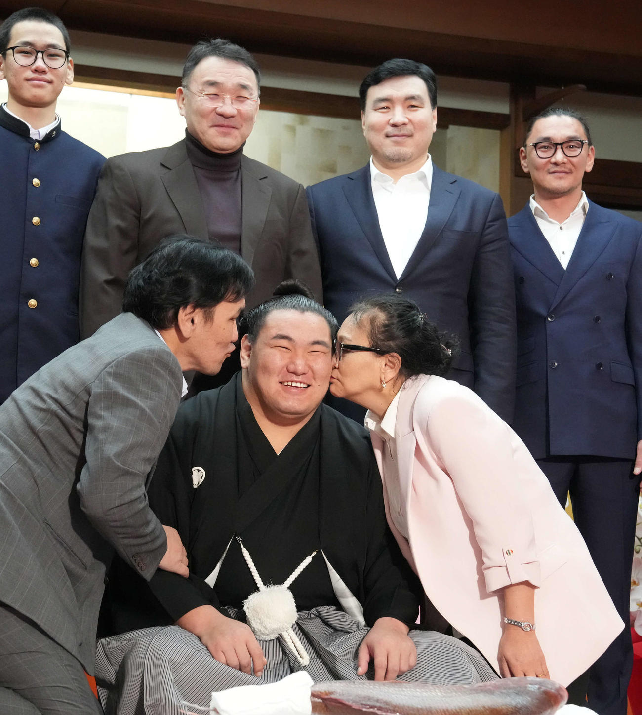 横綱昇進伝達式を終えた豊昇龍（中央）は父スガラグチャーさん（左）母ナルマンダフさん（右）から祝福のキスを受けながら家族と記念撮影に臨む（撮影・小沢裕）