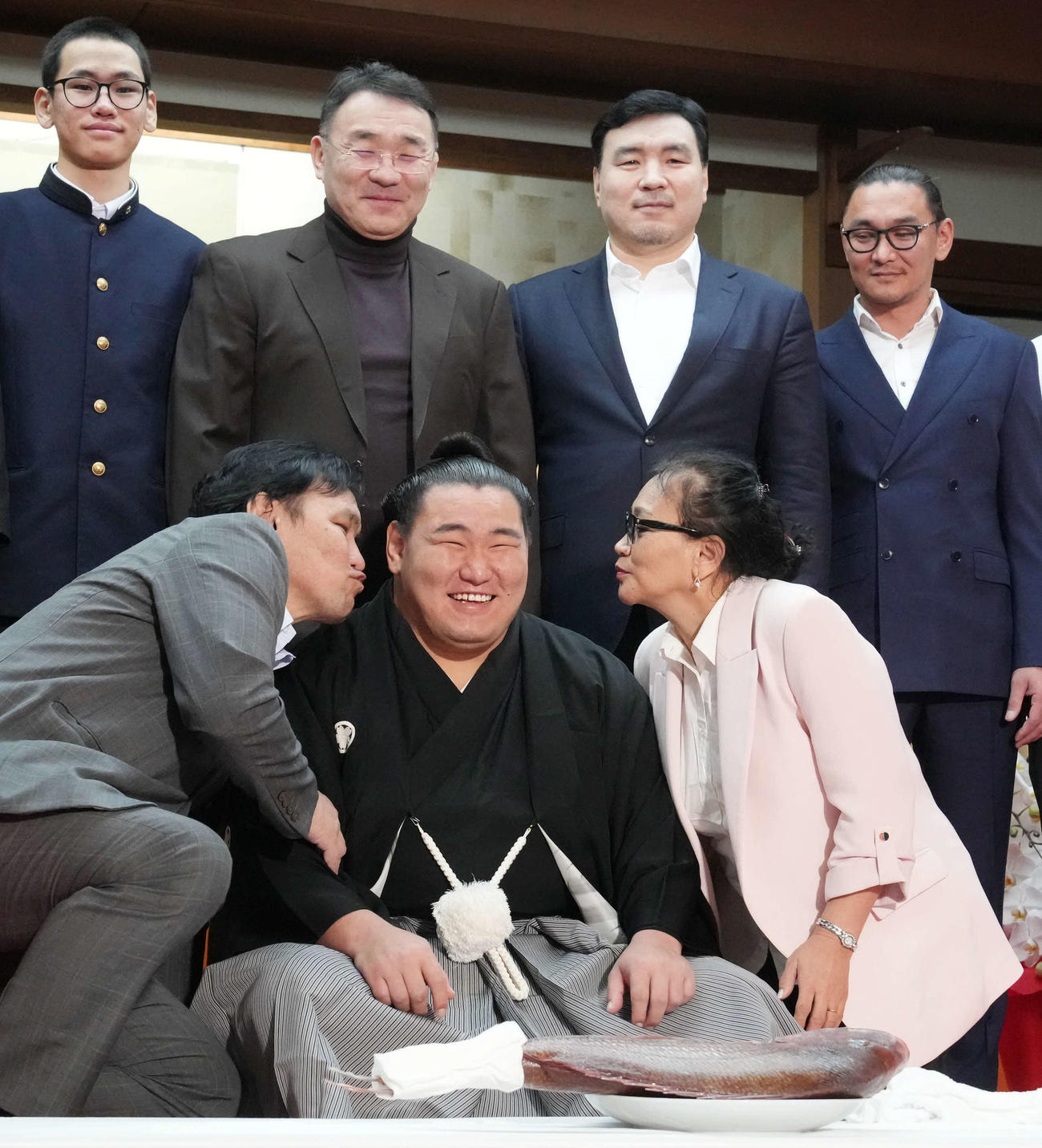 横綱昇進伝達式を終えた豊昇龍（中央）は父スガラグチャーさん（左）母ナルマンダフさん（右）から祝福のキスを受けながら家族と記念撮影に臨む（撮影・小沢裕）