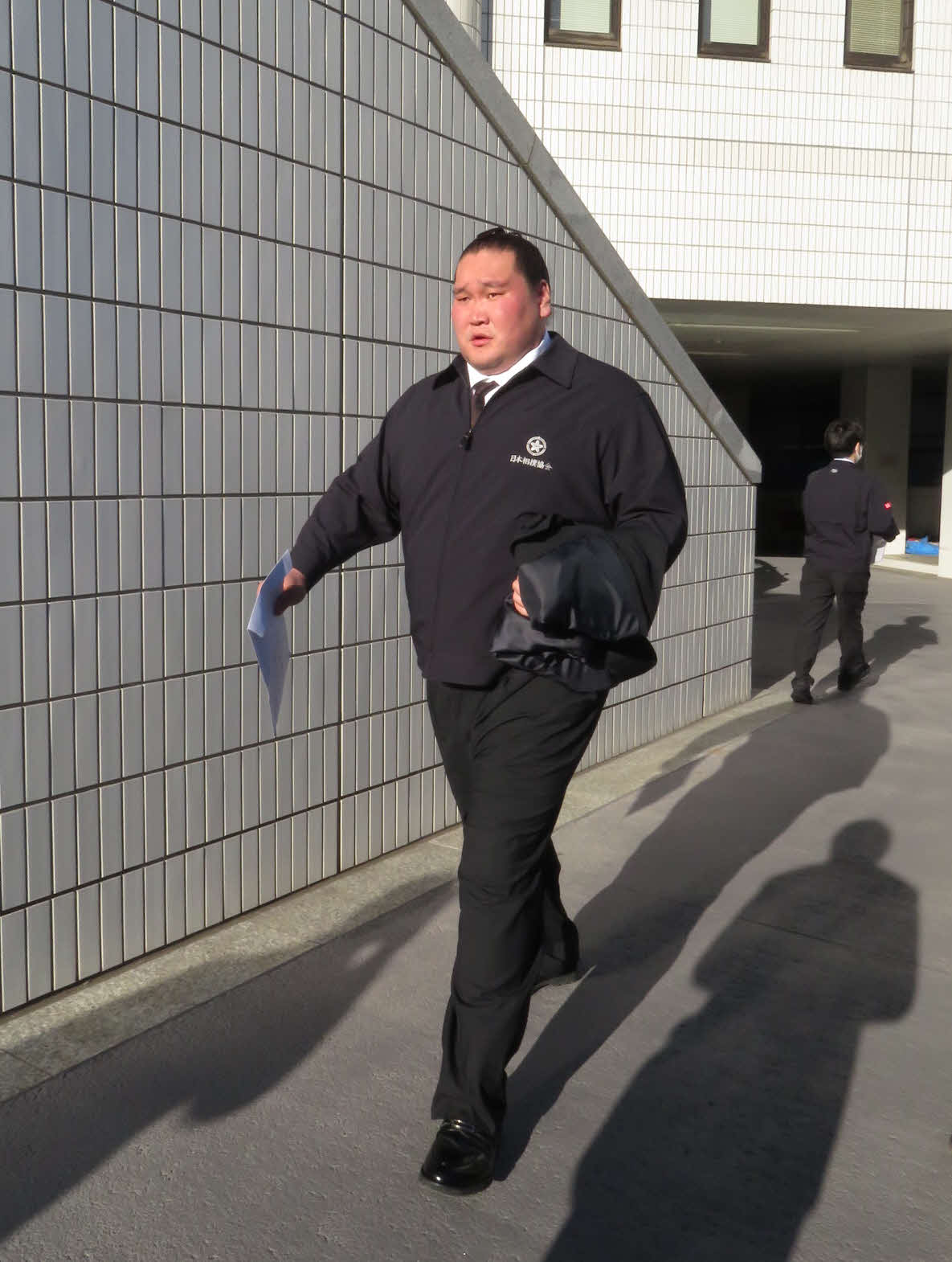 親方初仕事の年寄総会を終え、購入したばかりのスーツの上から配布されたジャンパーを着て帰途に就く照ノ富士親方