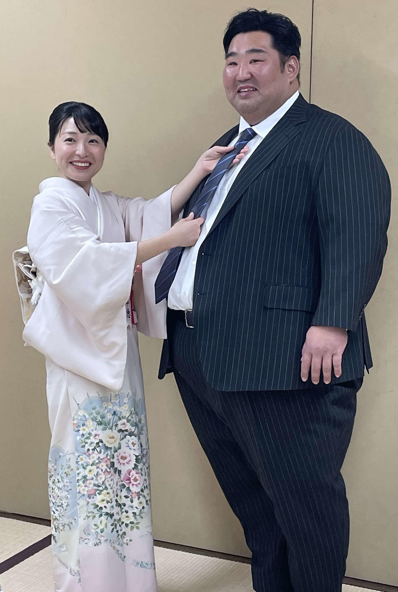 断髪式を終えた元幕内徳勝龍の千田川親方（右）と、ネクタイを締めてあげる千恵夫人