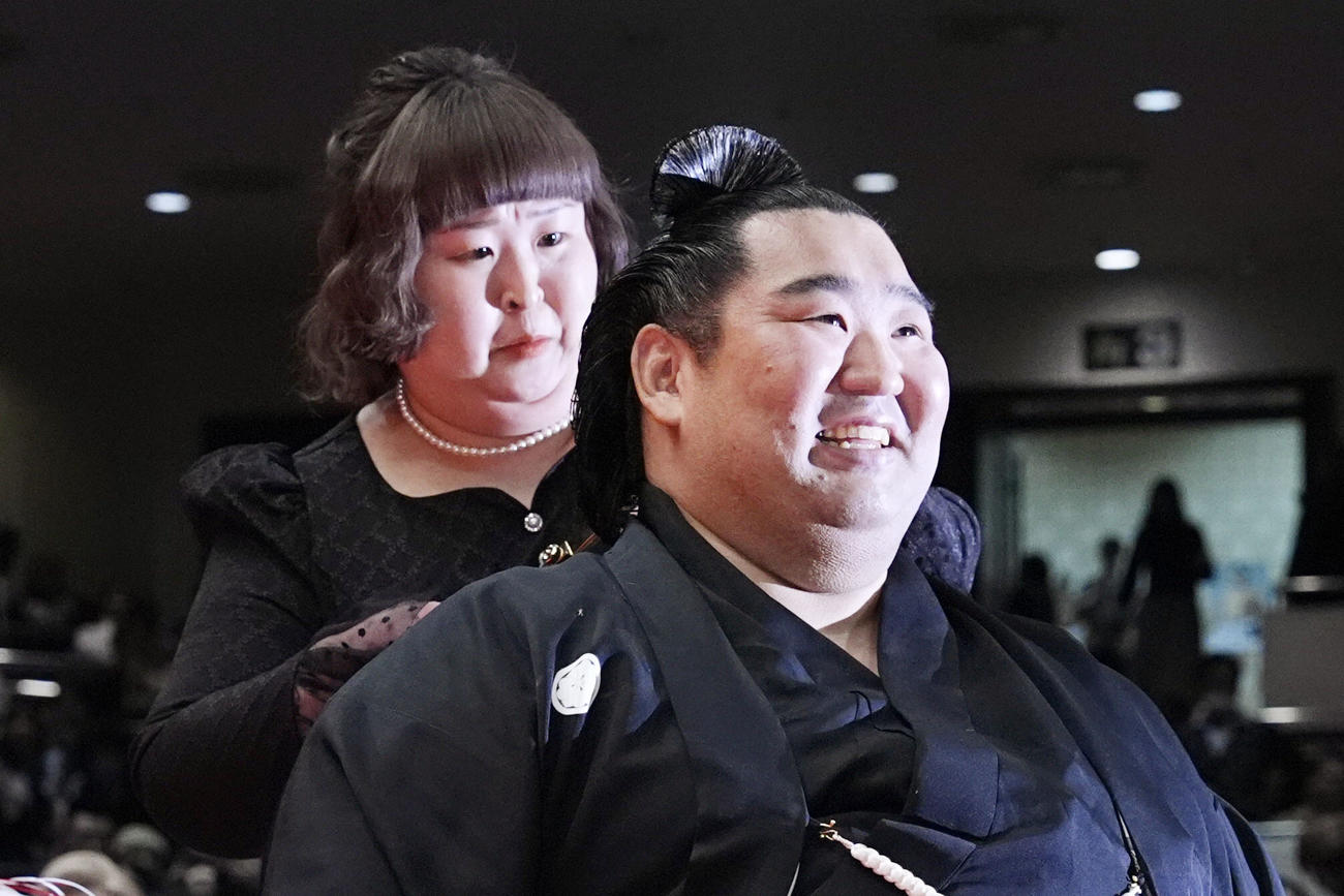 お笑いトリオ「3時のヒロイン」かなで（左）にはさみを入れられる元幕内徳勝龍の千田川親方（共同）