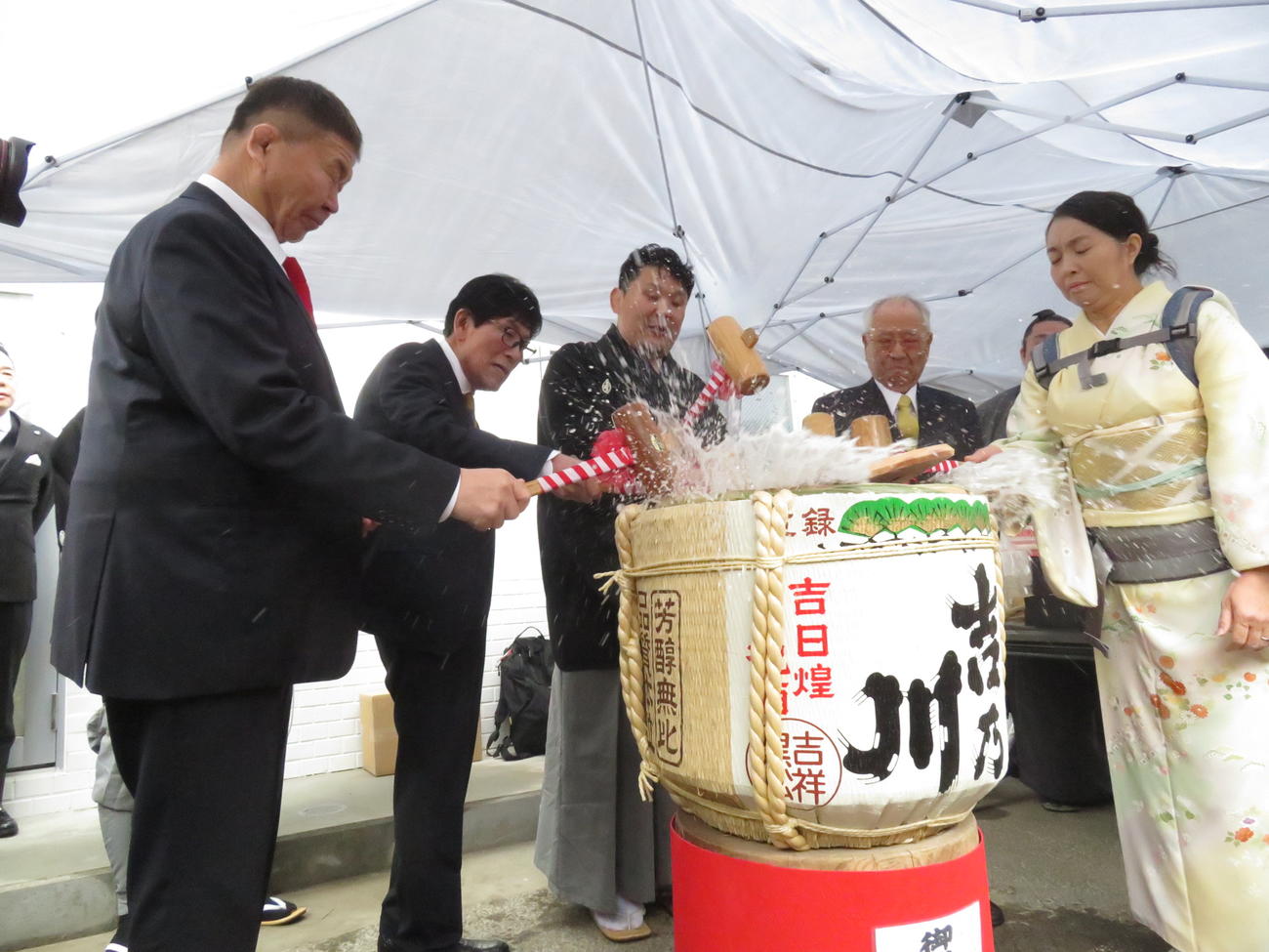 部屋開きの最後に、後援者らと勢いよく鏡開きを行った高砂親方（左から3人目）とデルゲレツェツェゲ夫人（右端）