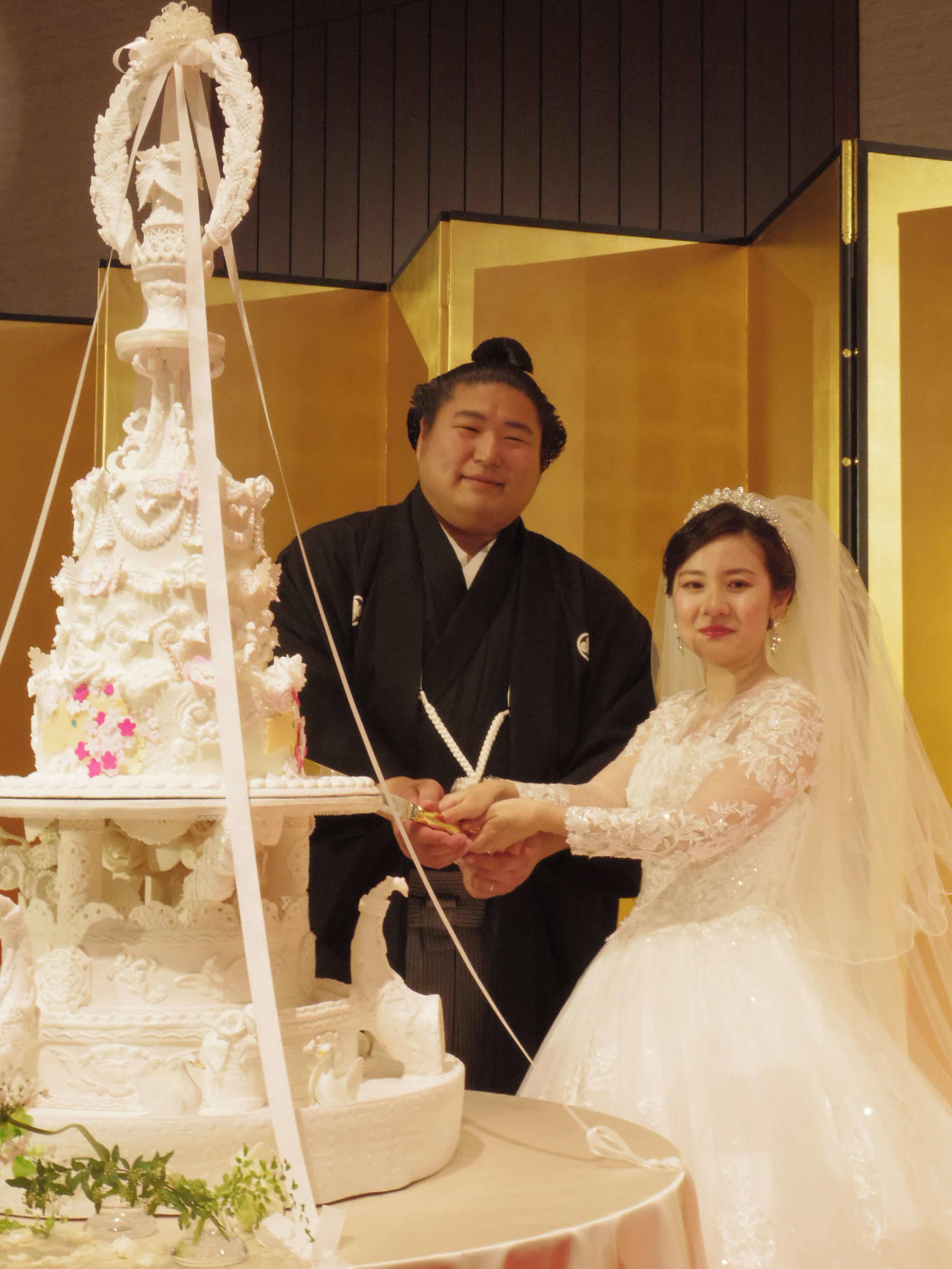結婚披露宴でケーキに入刀する若元春（左）と妻美岬さん