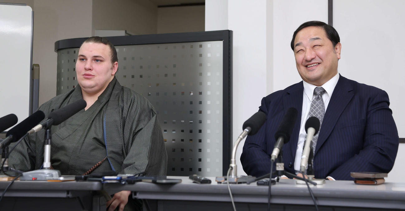 新入幕の安青錦（左）は師匠の安治川親方とともに笑顔で会見に臨む（撮影・西尾就之）
