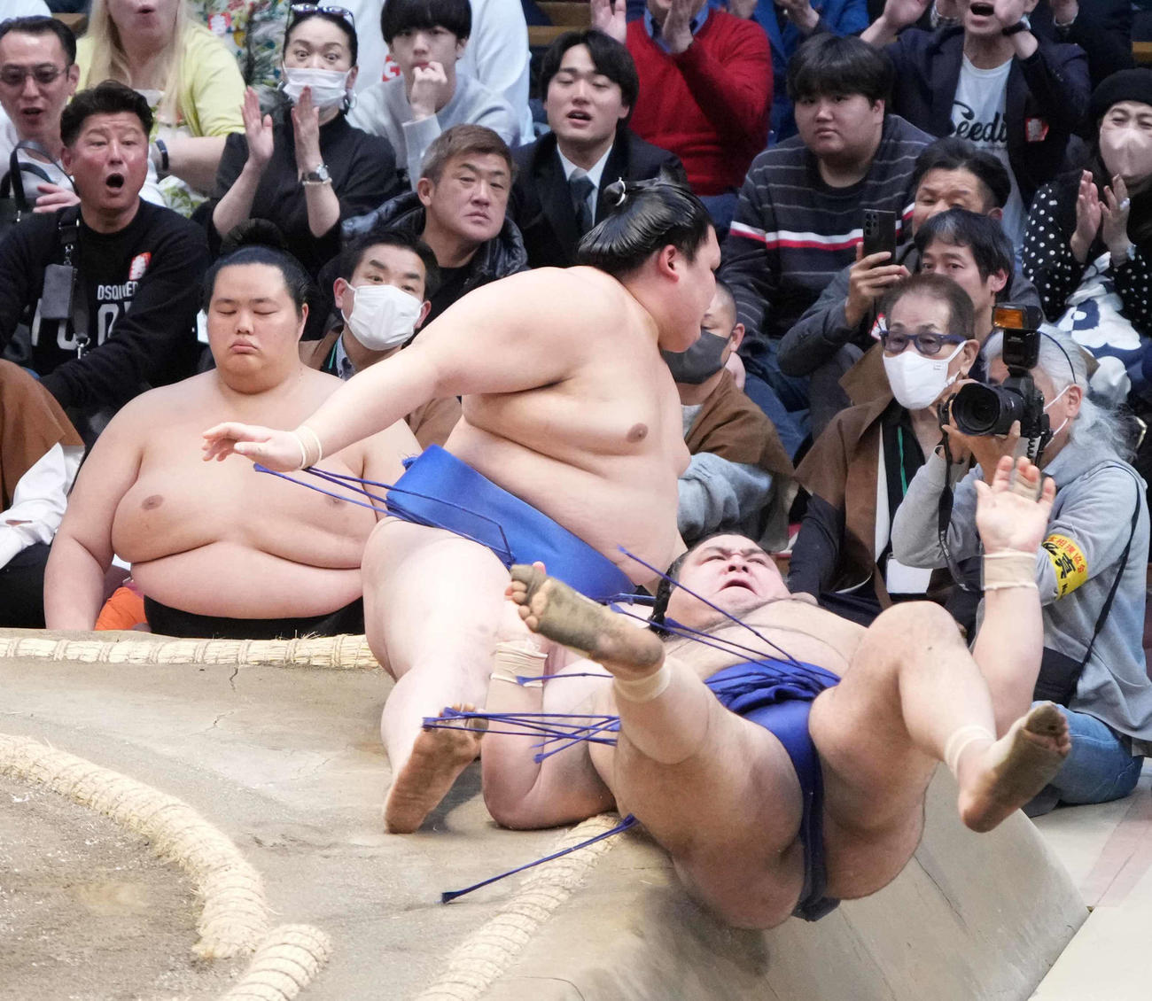 高安（手前）は寄り切りで大の里を破る。左は土俵下控えの琴桜（撮影・小沢裕）