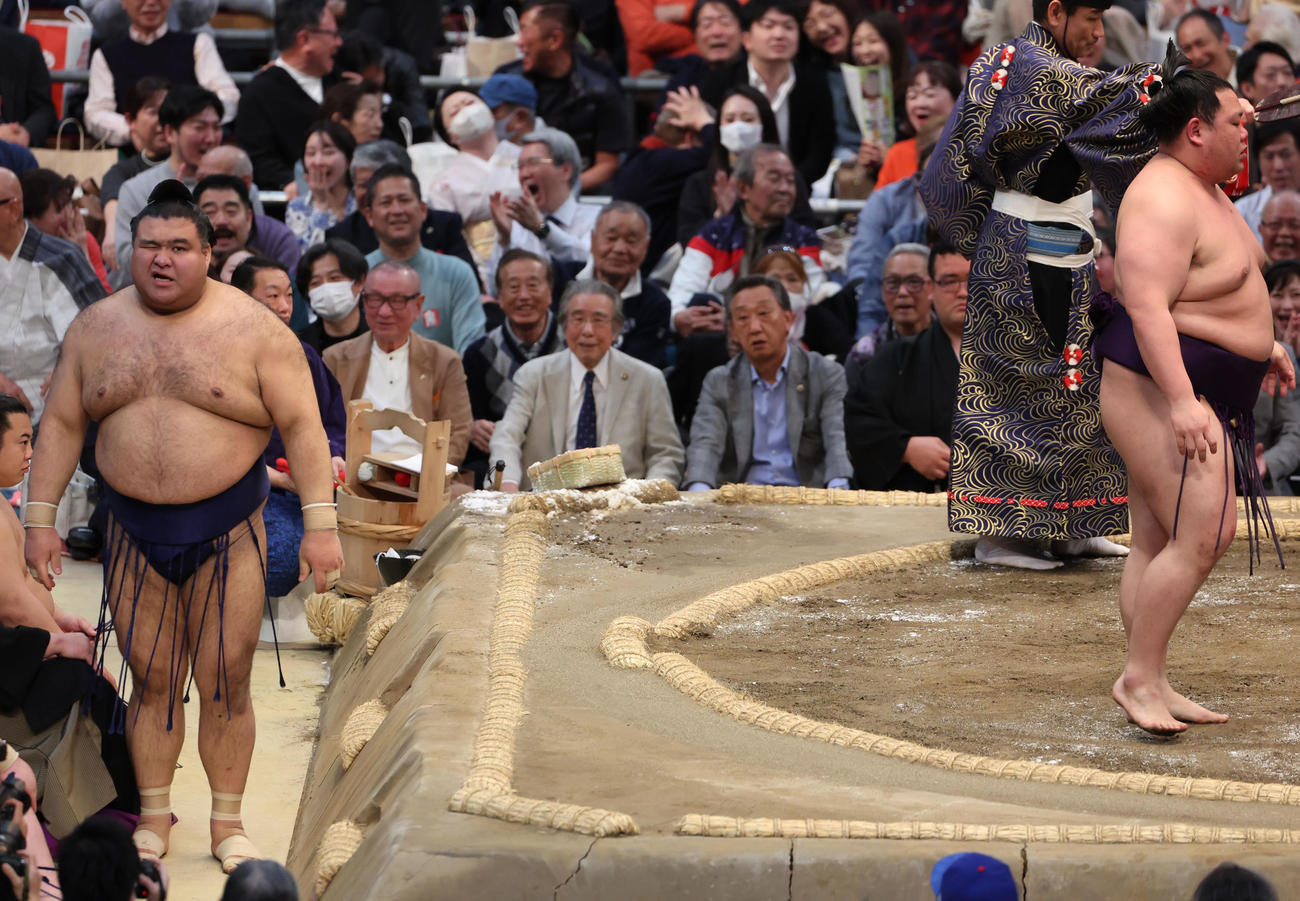 高安（左）は美ノ海に寄り切りで敗れ、この日の優勝決定はお預けとなり土俵下で顔をしかめる（撮影・西尾就之）
