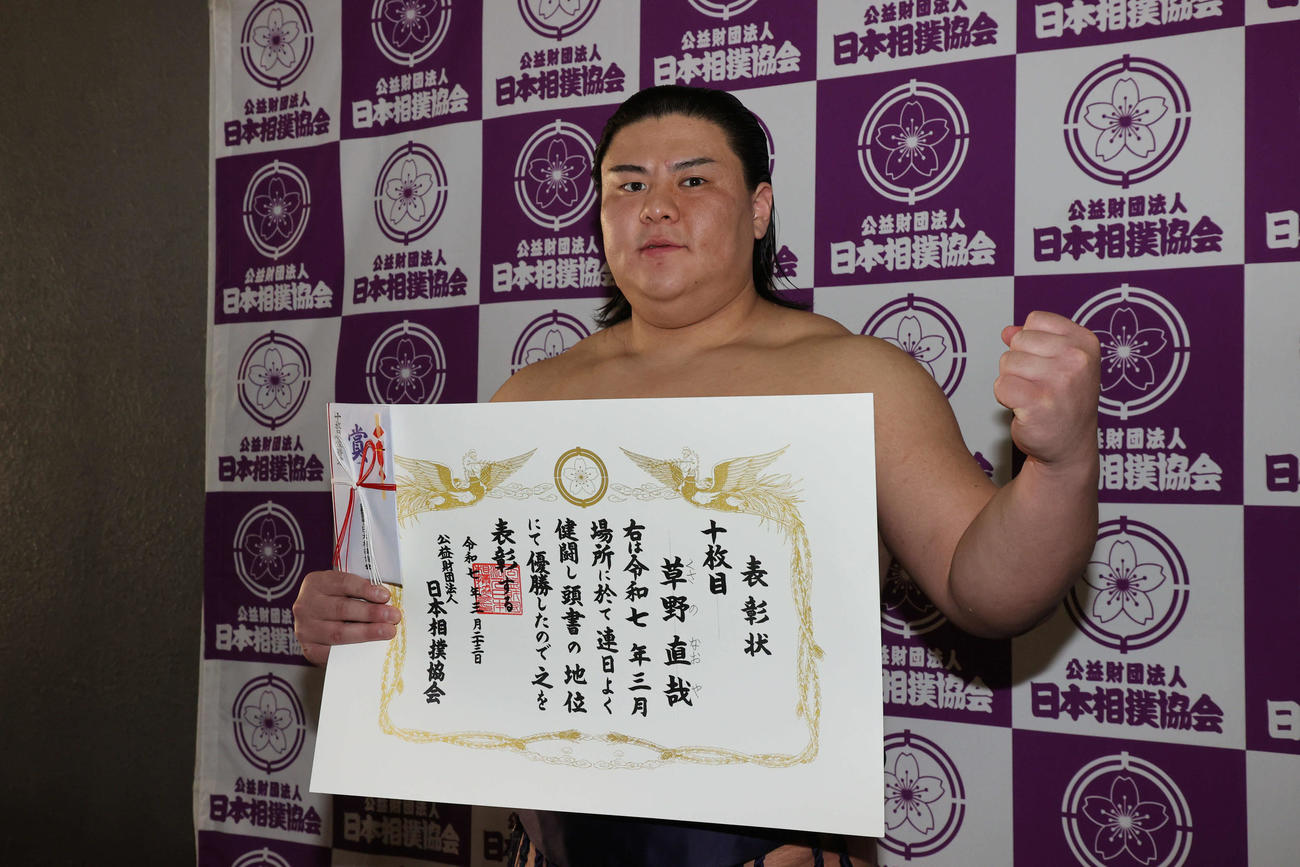 十両優勝の草野は賞状を手にガッツポーズ