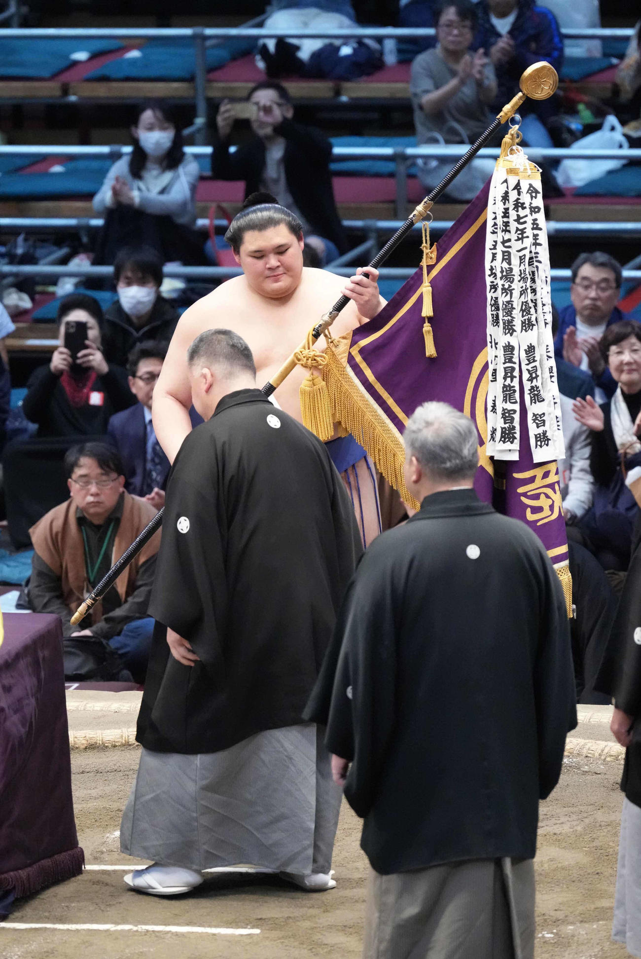 高田川審判部長（左）から優勝旗を受け取る大の里（撮影・小沢裕）