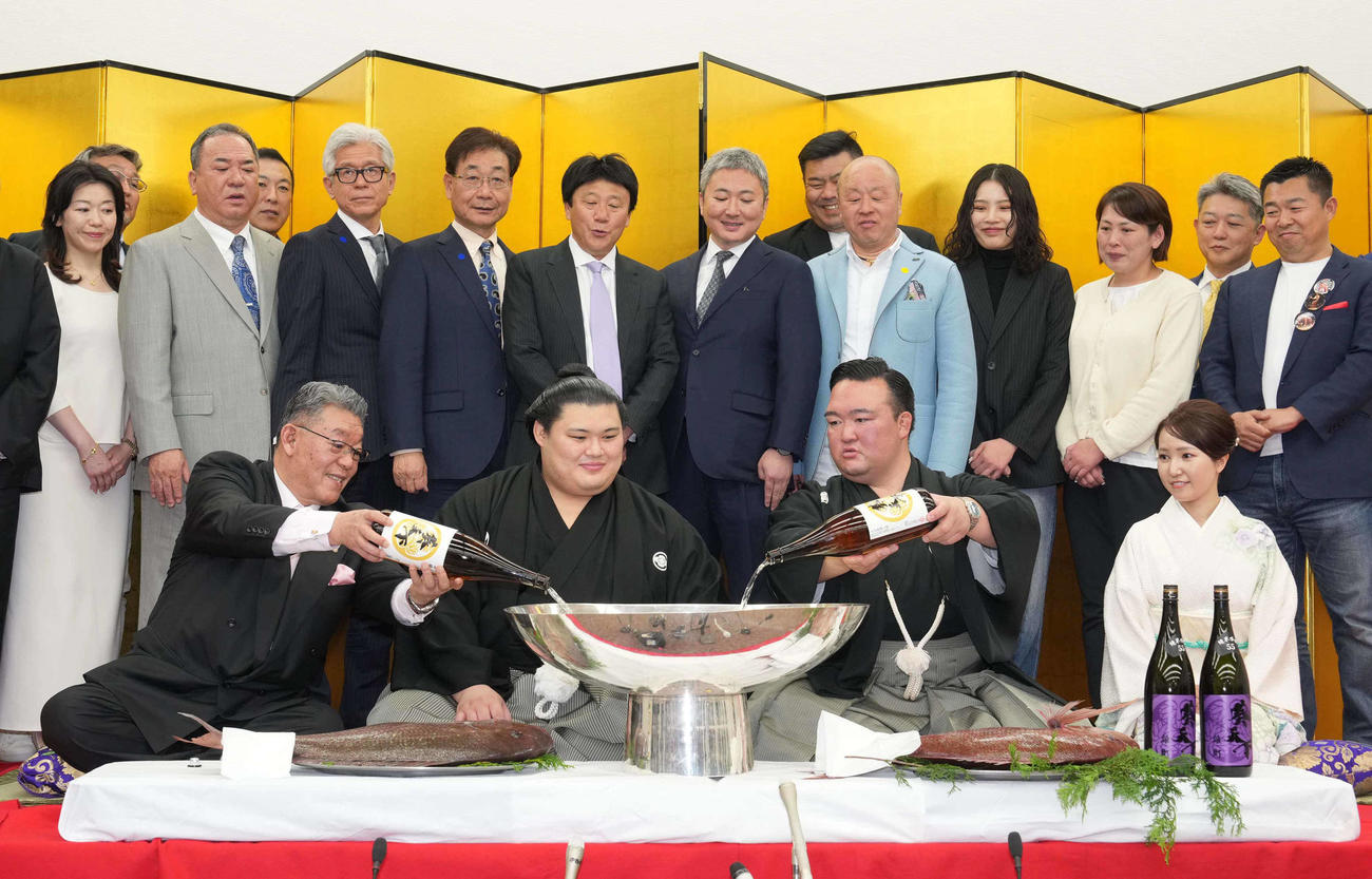 関係者が見守るなか、前列左から二所ノ関部屋大東後援会の橋本会長、1人おいて師匠の二所ノ関親方からお祝いのお酒を銀杯に注がれる大の里（撮影・小沢裕）
