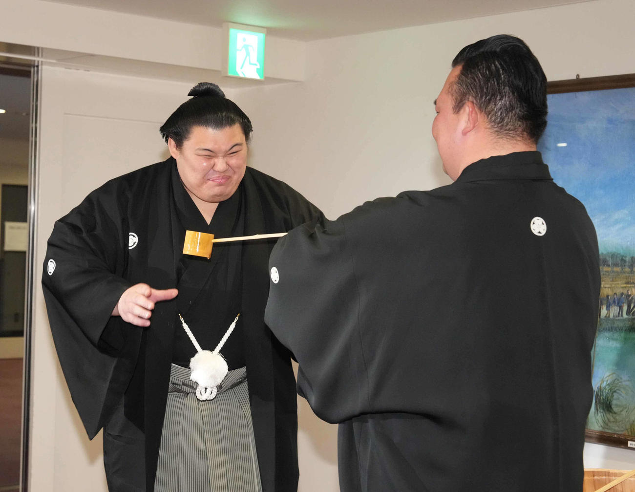 師匠の二所ノ関親方（右）から水をつけてもらい笑顔を見せる大の里（撮影・小沢裕）