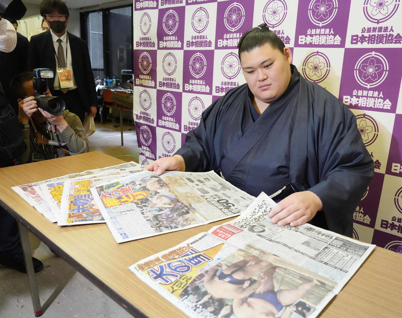 一夜明け会見で優勝を報じたスポーツ各紙に目を通す大の里（撮影・小沢裕）