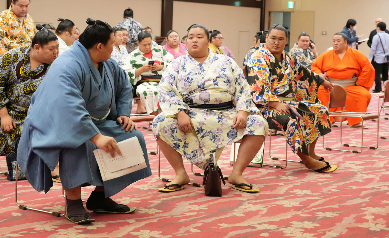 力士会に臨んだ大の里（左）は豊昇龍（右奥）に声を掛けられて場所を移動する。中央は琴桜（撮影・小沢裕）