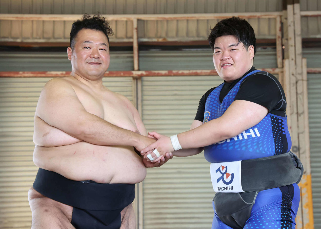 2人の目標は世界一への返り咲き。握手する立飛女子相撲部コーチに就任した大相撲の元関脇でタレントの豊ノ島と部員の久野愛莉（撮影・丹羽敏通）