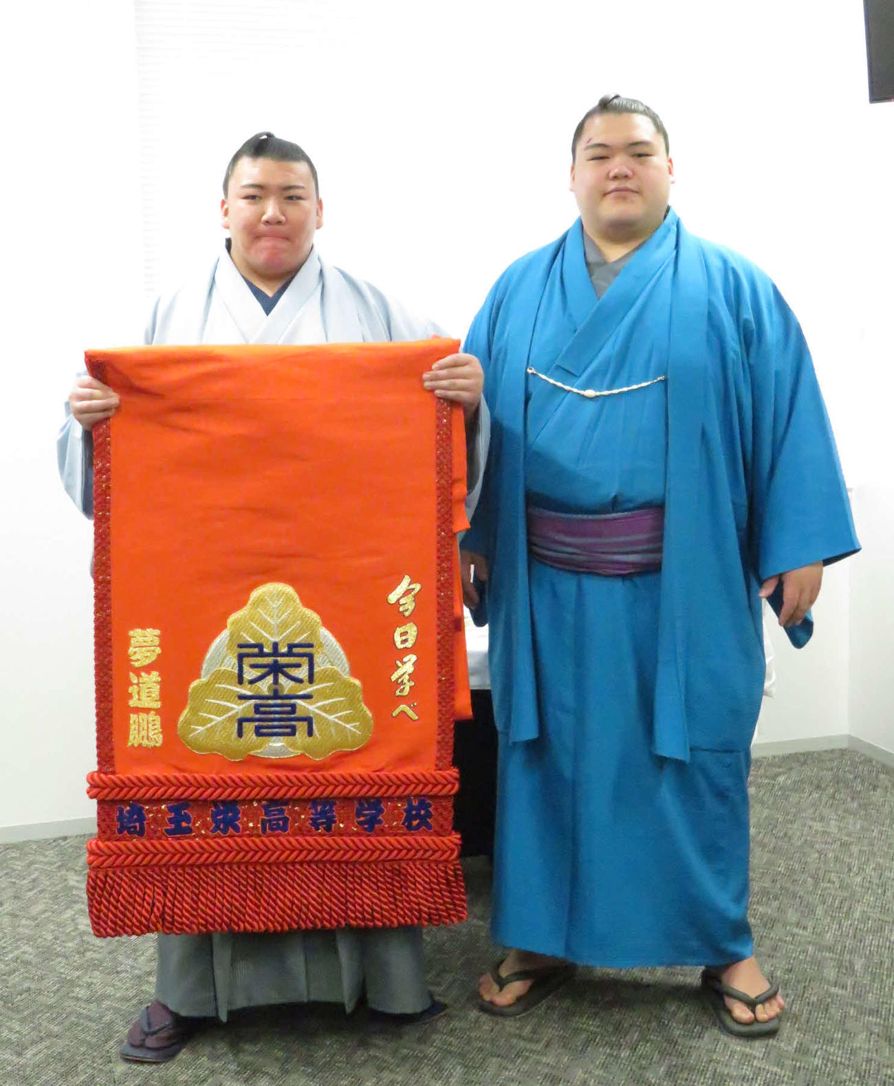 母校の埼玉栄高から化粧まわしを贈呈された夢道鵬（左）は、兄の王鵬と記念撮影に納まった