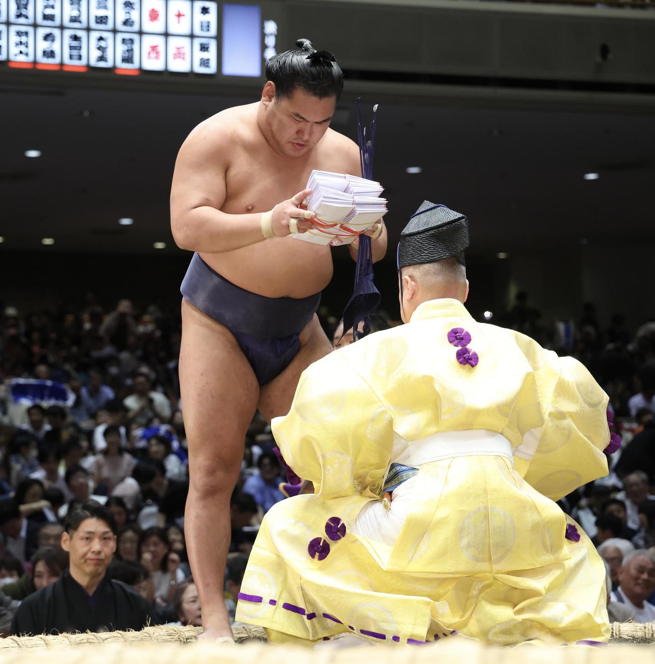 若隆景を押し出しで破り、懸賞金の束を手にする豊昇龍（撮影・河田真司）