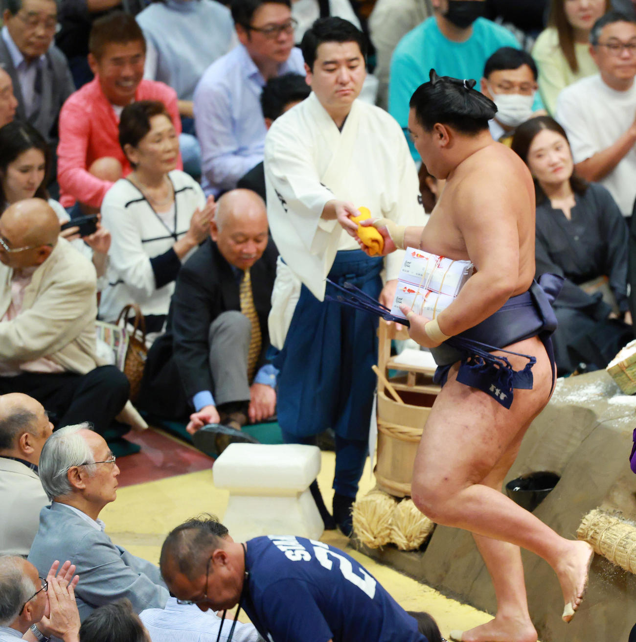 懸賞金の束を抱え花道へ向かう豊昇龍（撮影・中島郁夫）