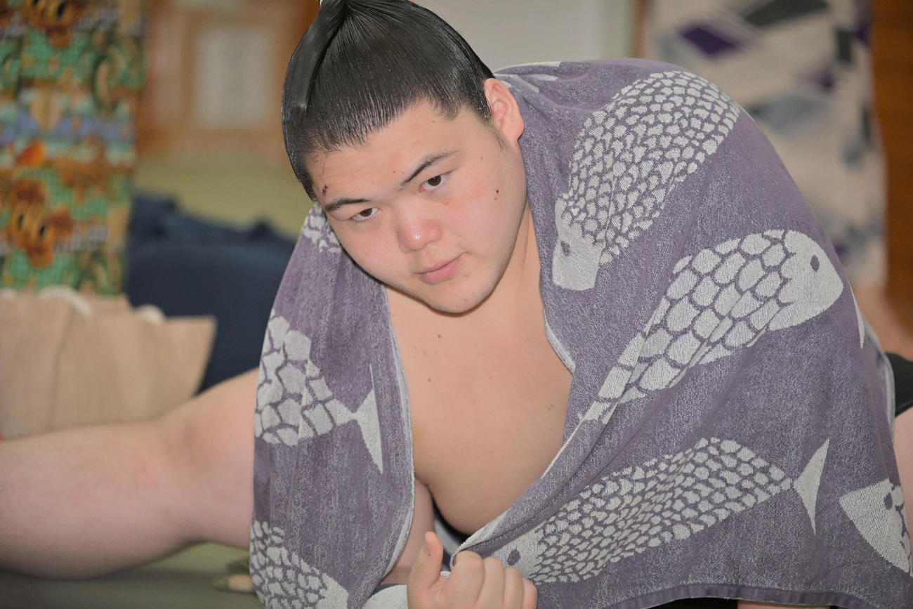 支度部屋で髪を整えストレッチする王鵬