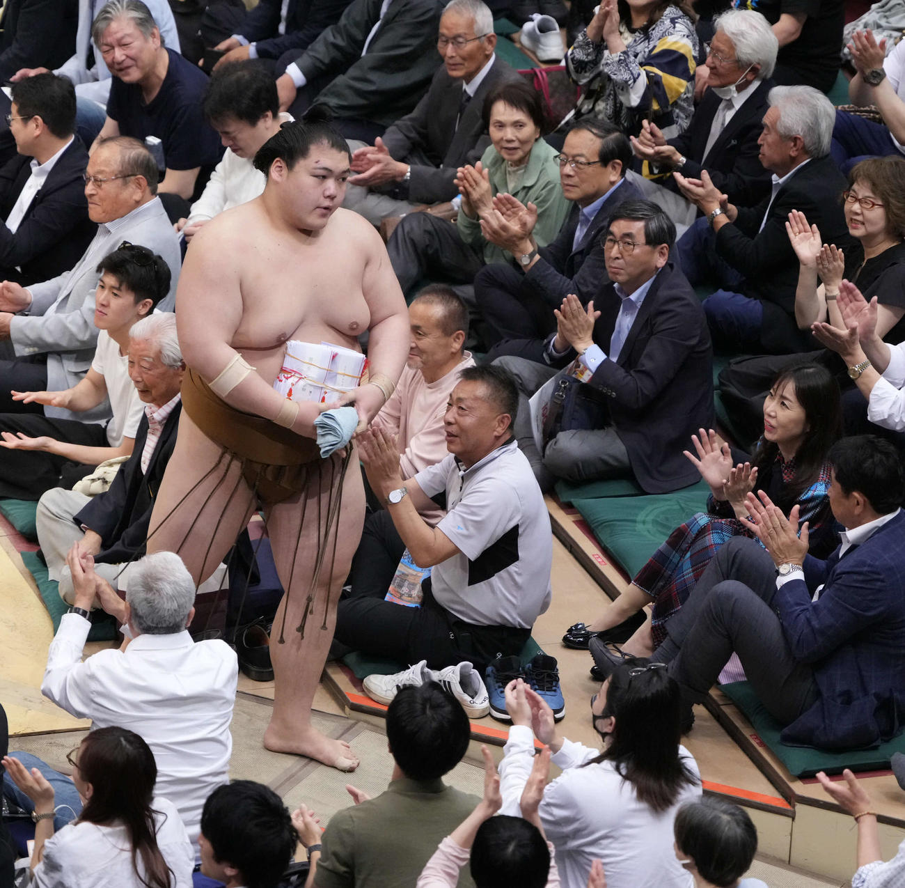 懸賞金の束を手に花道を引き揚げる王鵬（撮影・小沢裕）