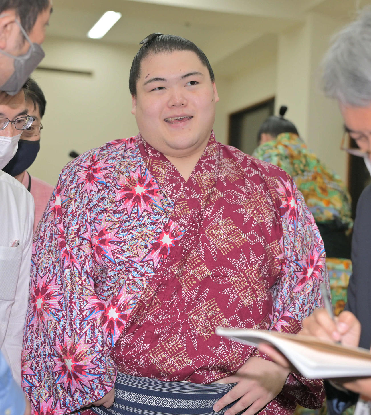 支度部屋で報道陣に囲まれ笑顔を見せる王鵬