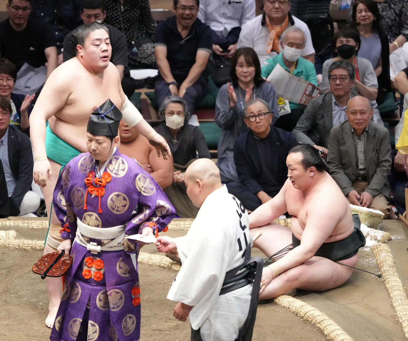 一山本（左）は千代翔馬を寄り倒しで破る。千代翔馬の右上で観戦しているのが、チェックのシャツにグレーのジャケット姿の瀧川鯉昇（撮影・小沢裕）