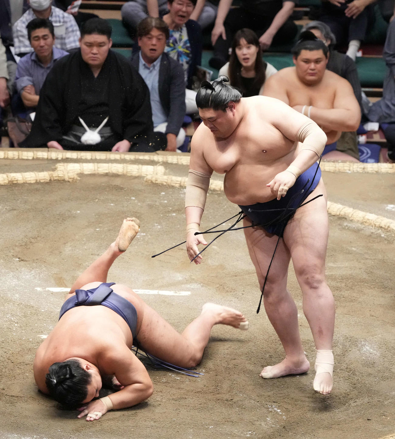 豊昇龍（左）は阿炎に引き落としで敗れる。右奥は土俵下控えの大の里（撮影・小沢裕）