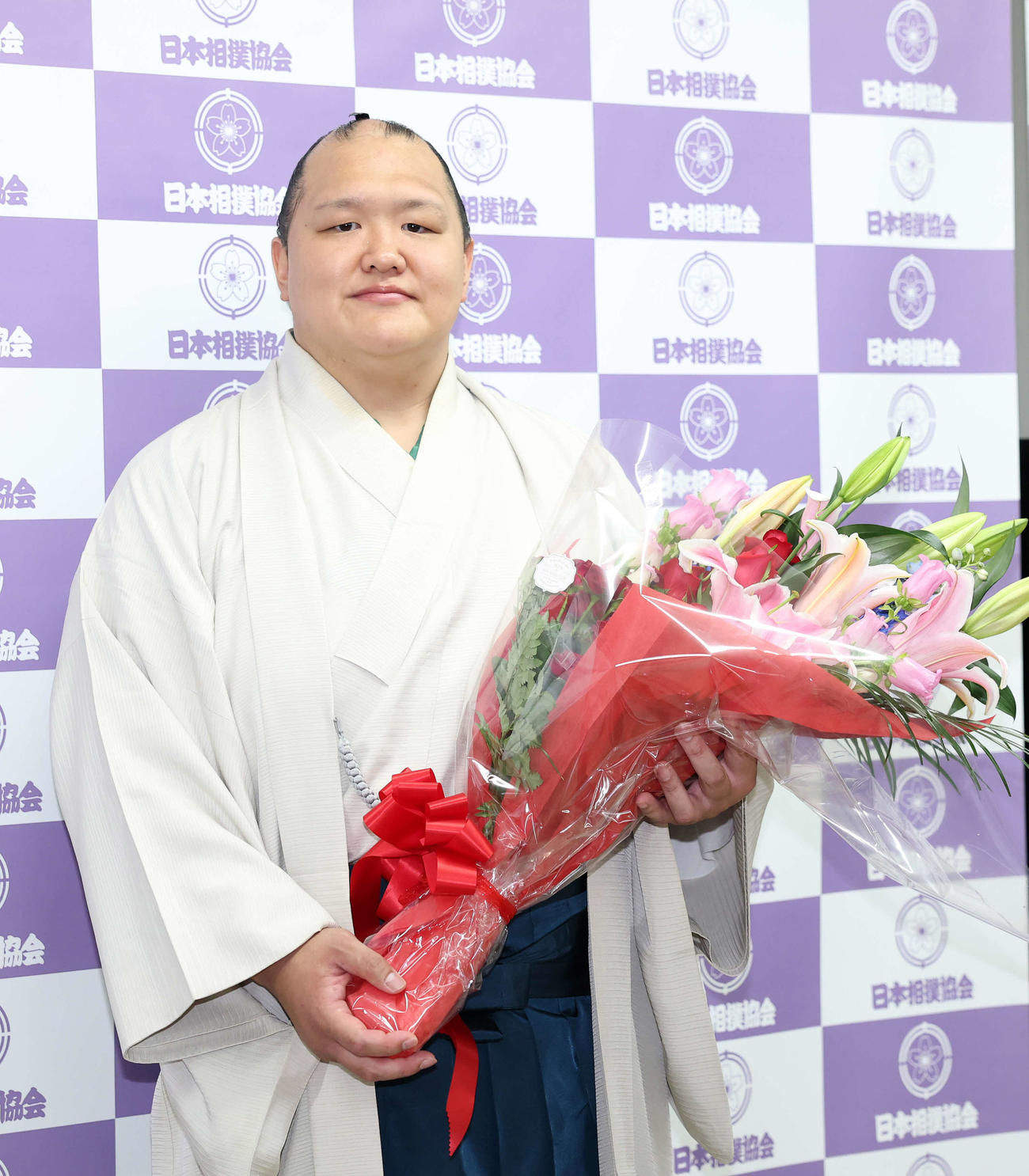 花束を手に写真に納まる北勝富士（撮影・鈴木正人）