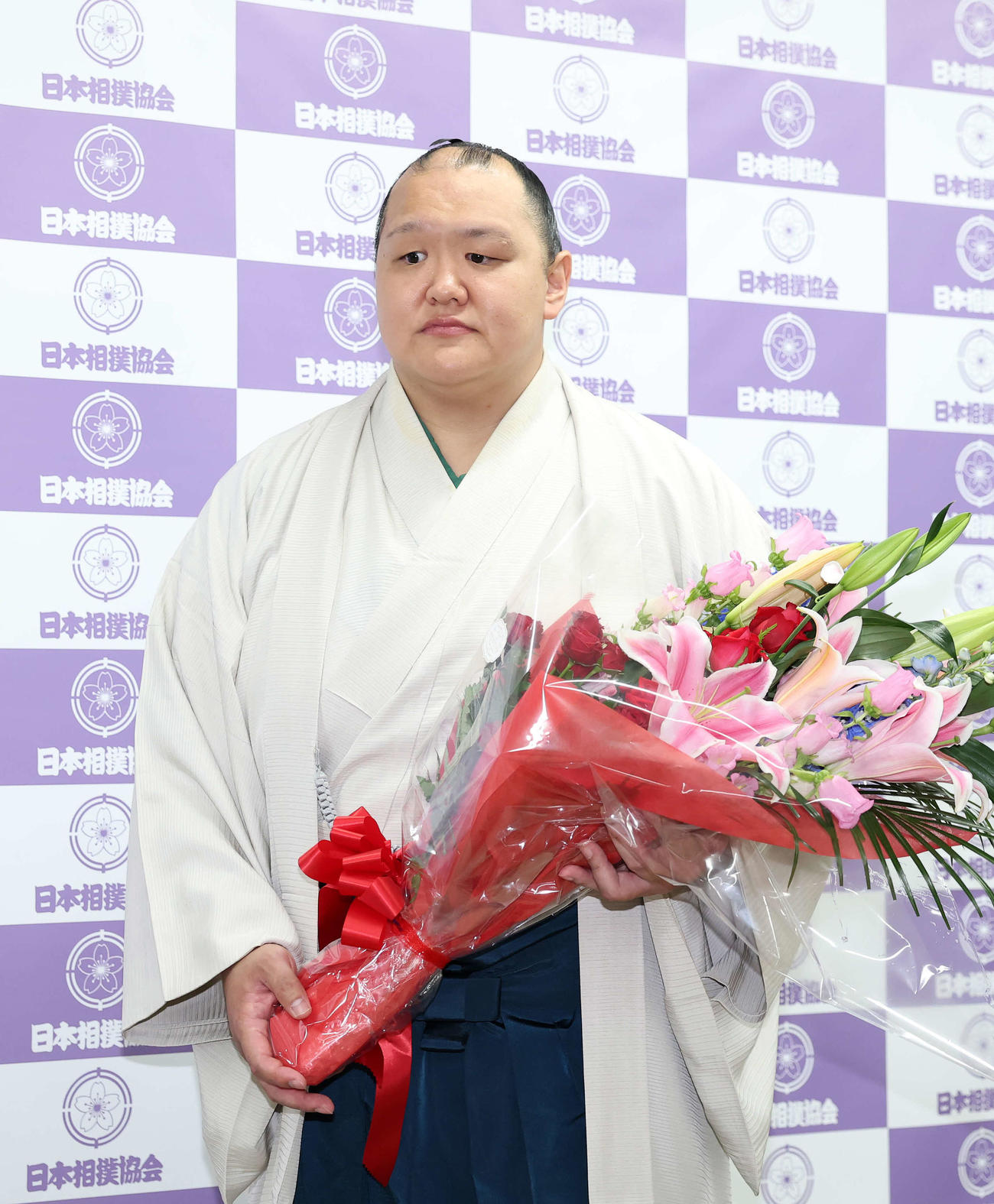 花束を手に会見場を引き揚げる北勝富士（撮影・鈴木正人）