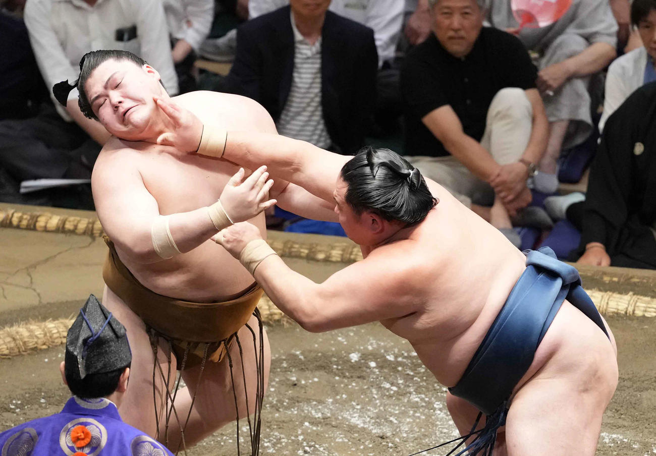 玉鷲（右）の攻めをこらえる王鵬（撮影・小沢裕）