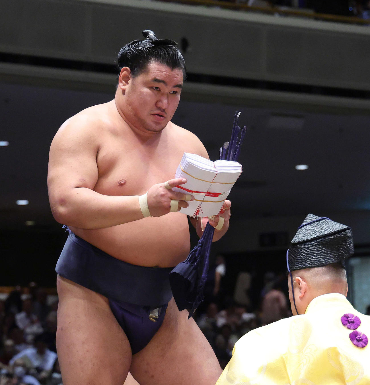 伯桜鵬の腰砕けで勝ち名乗りを受け、懸賞金の束を手にする豊昇龍（撮影・河田真司）