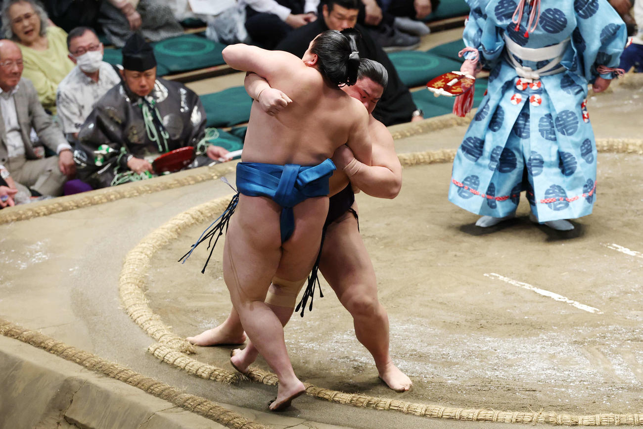 寄り切りで琴栄峰（手前）を破る草野（撮影・宮地輝）