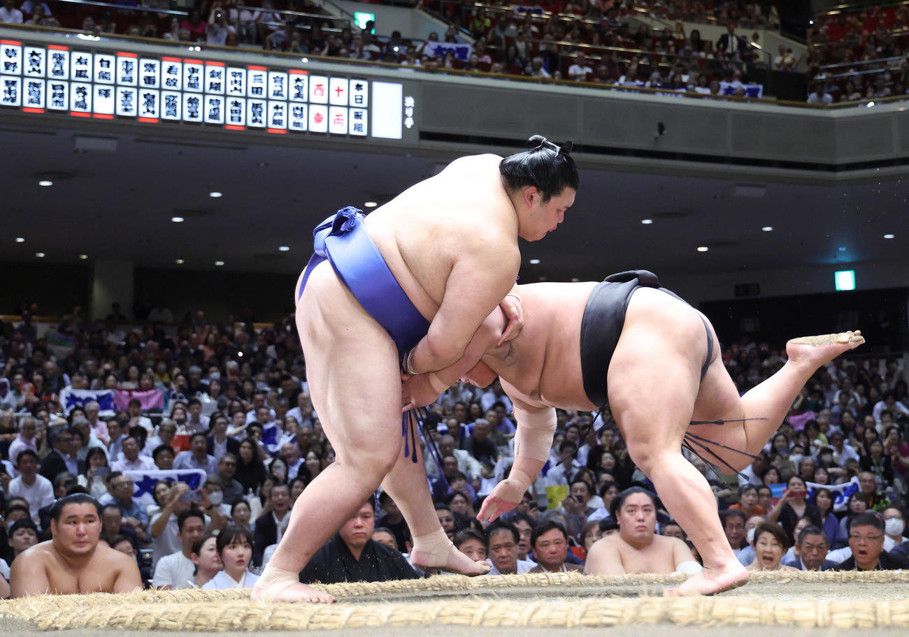 大の里（左）は伯桜鵬をはたき込みで破る。土俵下左は豊昇龍（撮影・河田真司）