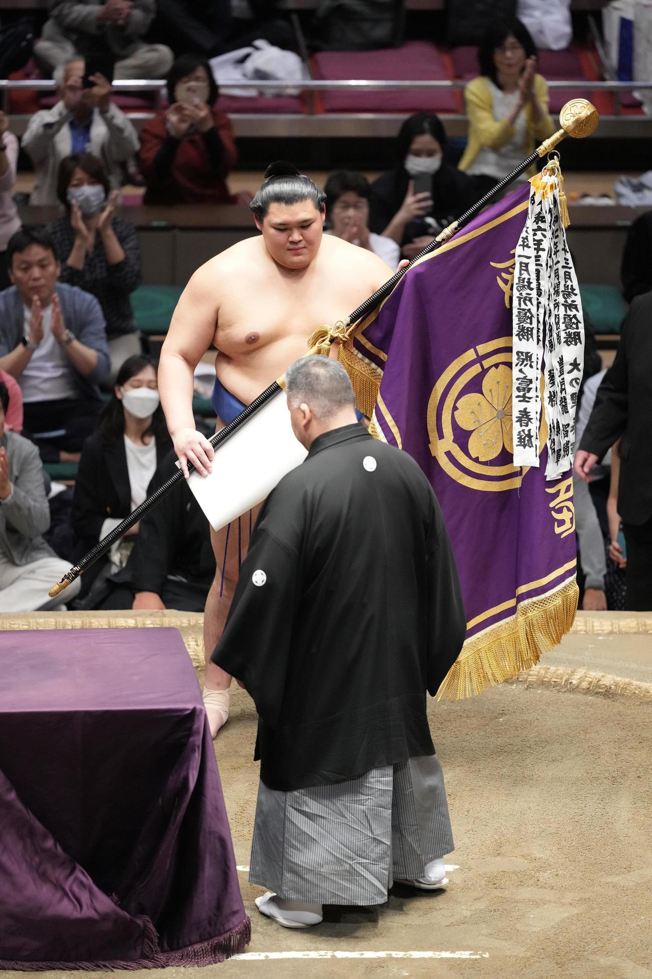 高田川審判部長（手前）から優勝旗を受け取る大の里（撮影・小沢裕）