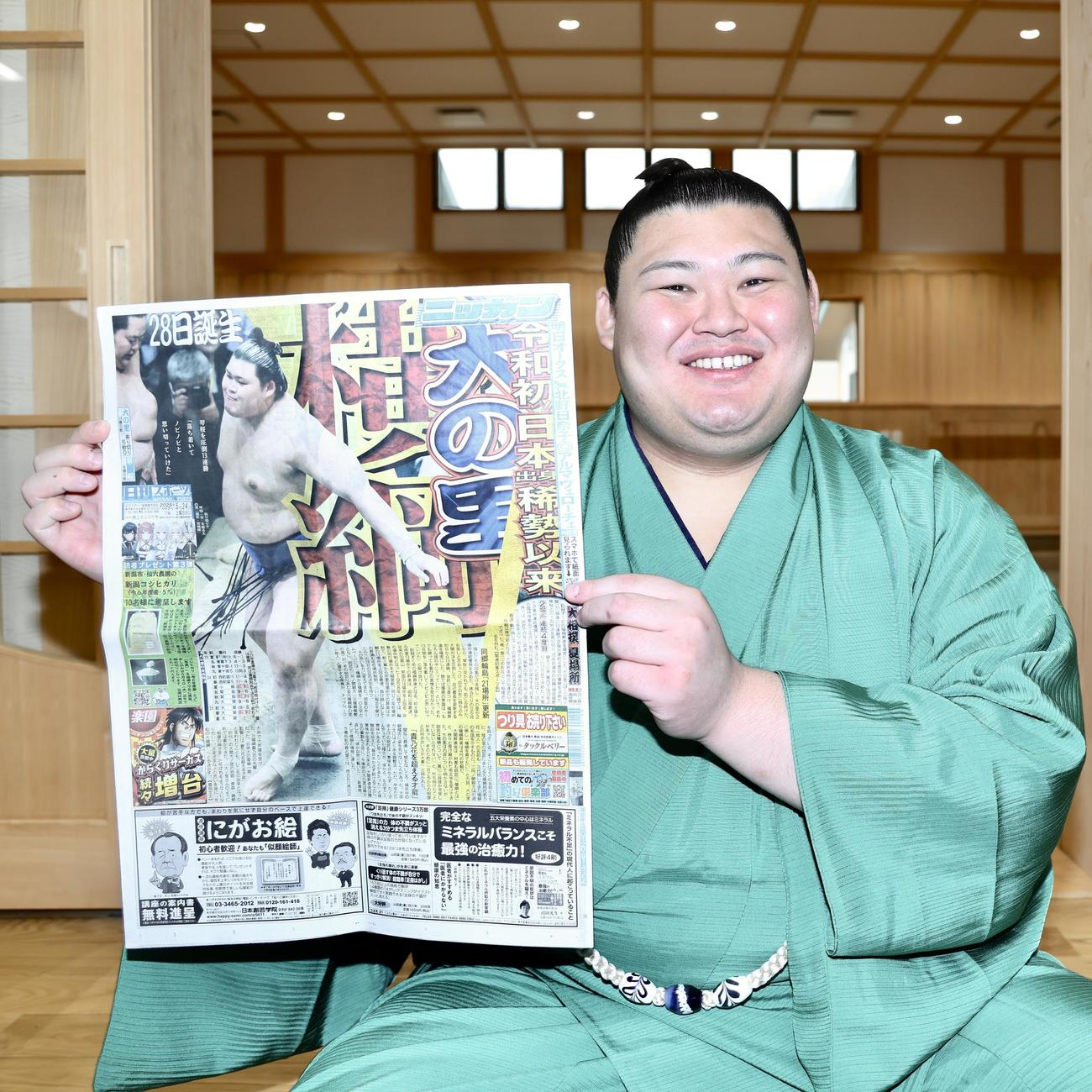 大相撲夏場所13日目の本紙面を手に笑顔を見せる大の里（撮影・河田真司）