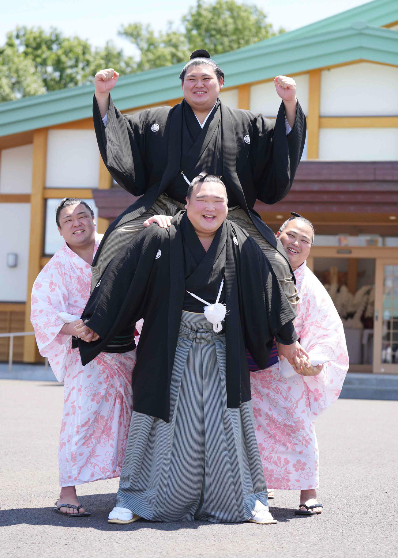 左から麒麟龍、白熊、花の海が作った騎馬に乗りガッツポーズする新横綱大の里（中央）（撮影・小沢裕）