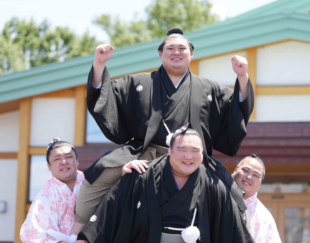 左から麒麟龍、白熊、花の海が作った騎馬に乗りガッツポーズする新横綱大の里（中央）（撮影・小沢裕）